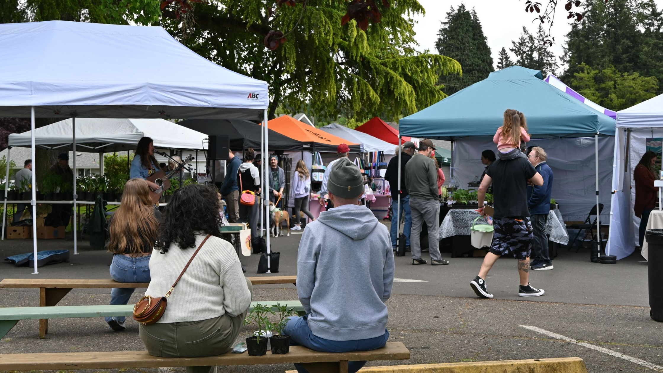 People sitting and enjoying the Ridgefield Farmers Market at Davis Park