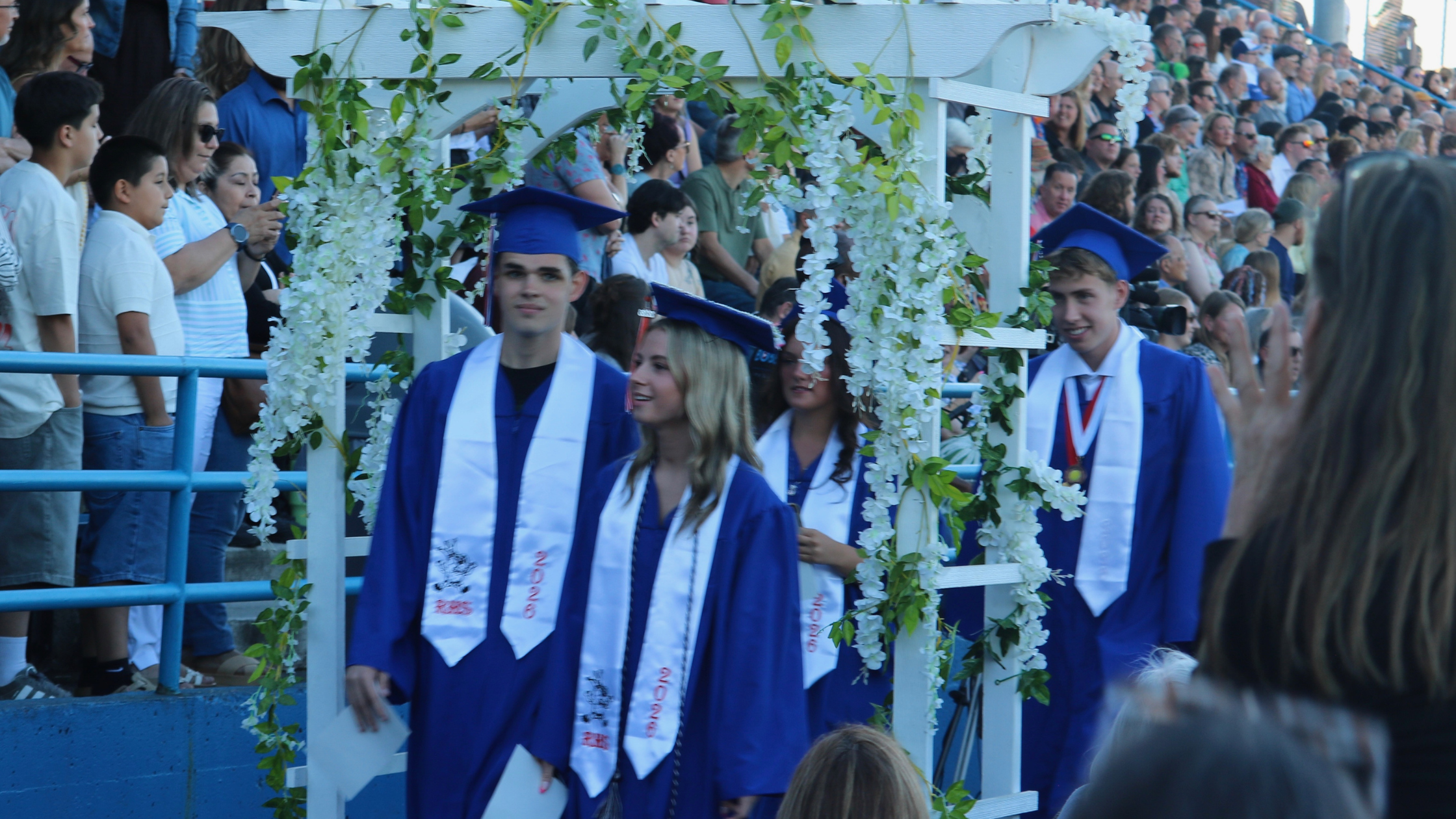 RHS Class of 2026 seniors walking through trellis toward their seats