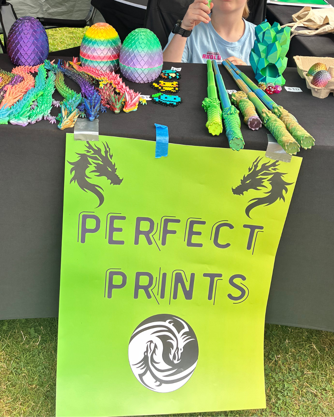 3D printed articulated dragons, dragon eggs and crystal shapes on a market table