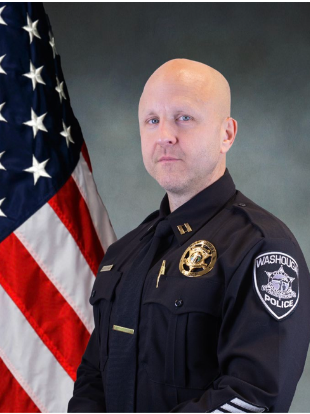 Jim Quackenbush, Ridgefield's incoming police chief, in uniform in front of an American flag